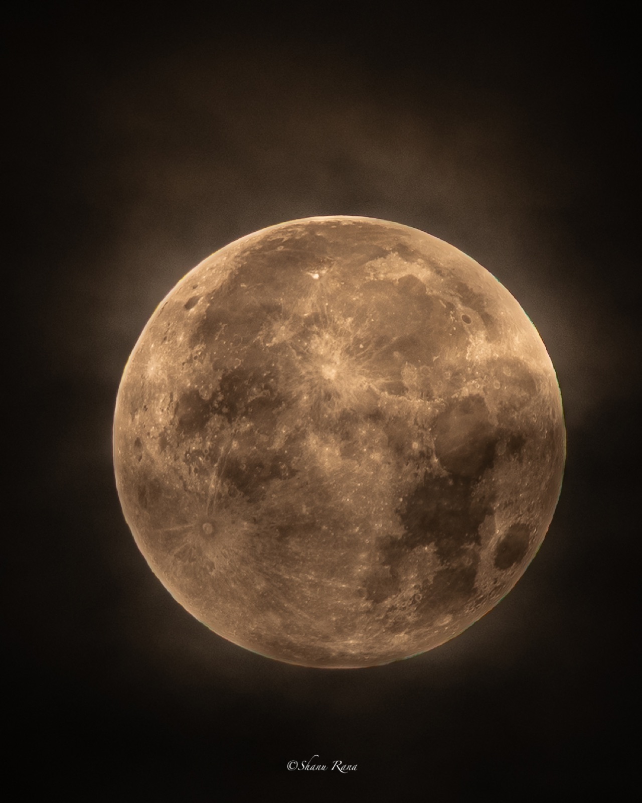Detailed full moon glowing through thin clouds