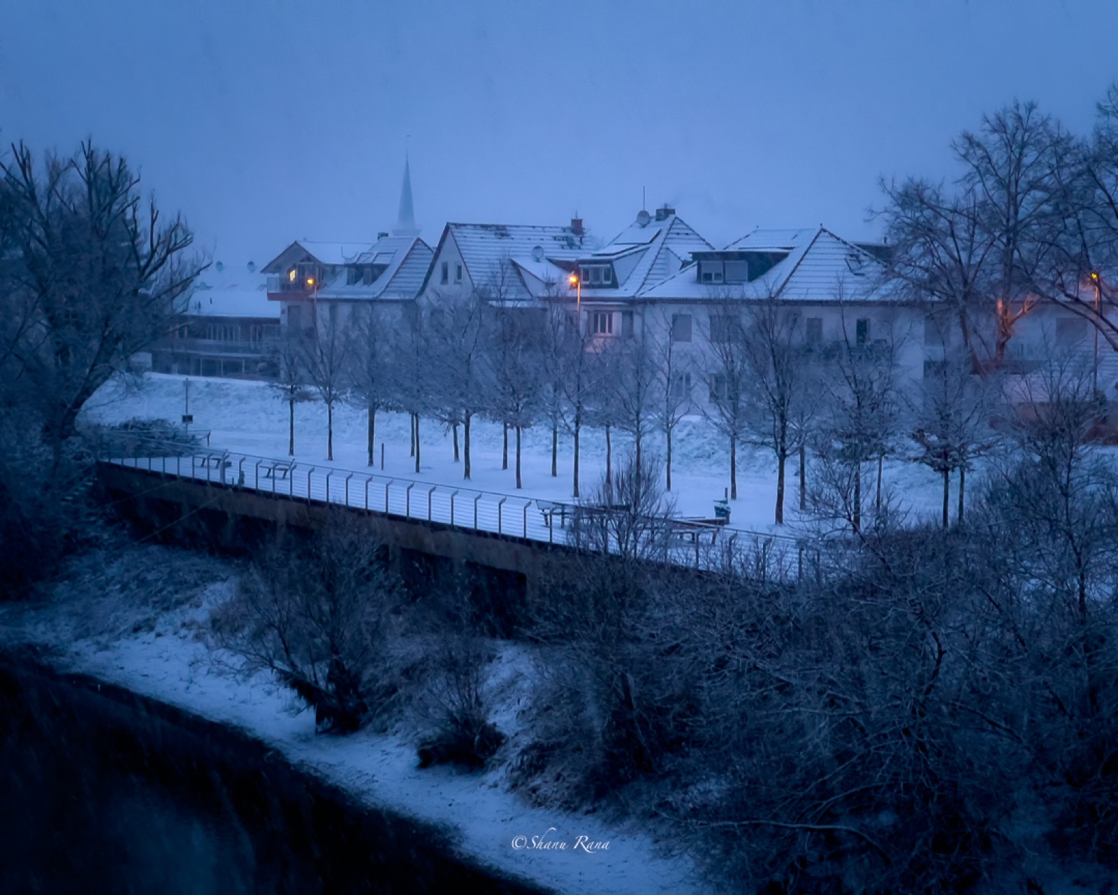 Snow-covered town and bridge at blue hour